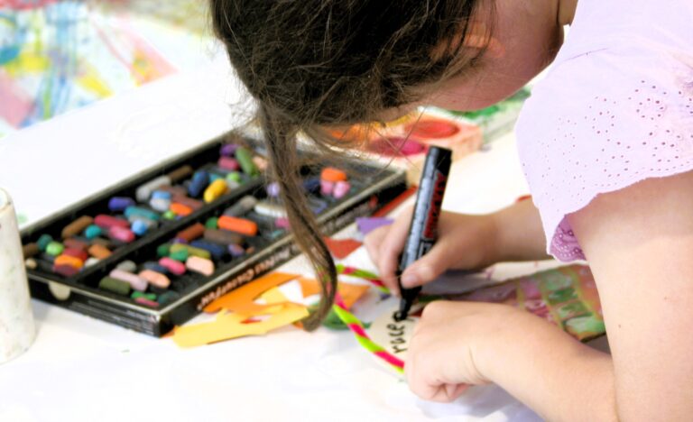 Child colouring and cutting recycled materials during a Kids Corner activity at the Adelaide Showground Farmers’ Market.