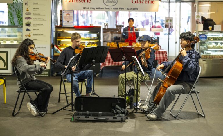 The Core Four string quartet performing live inside the Adelaide Showground Farmers’ Market, playing violins and cello among the market stalls