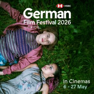 Two young women lying on green grass looking up, featured on the HSBC German Film Festival 2026 promotional image with event dates 6–27 May.