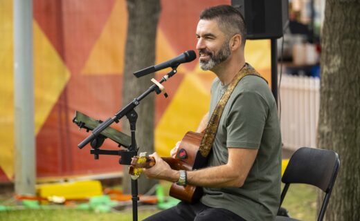 Busker Adam Moffatt performs live with acoustic guitar and vocals outdoors at the Adelaide Showground Farmers’ Market.