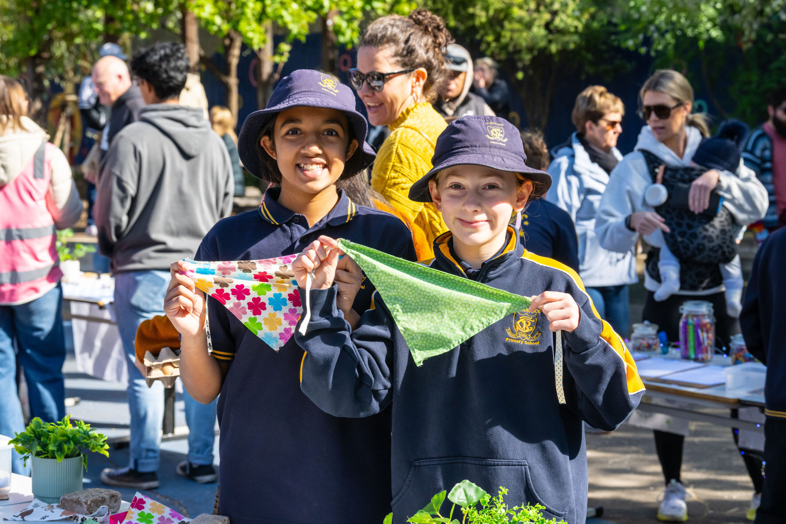 Two Goodwood Primary School students display colourful handmade fabric bunting at the Children’s Market.